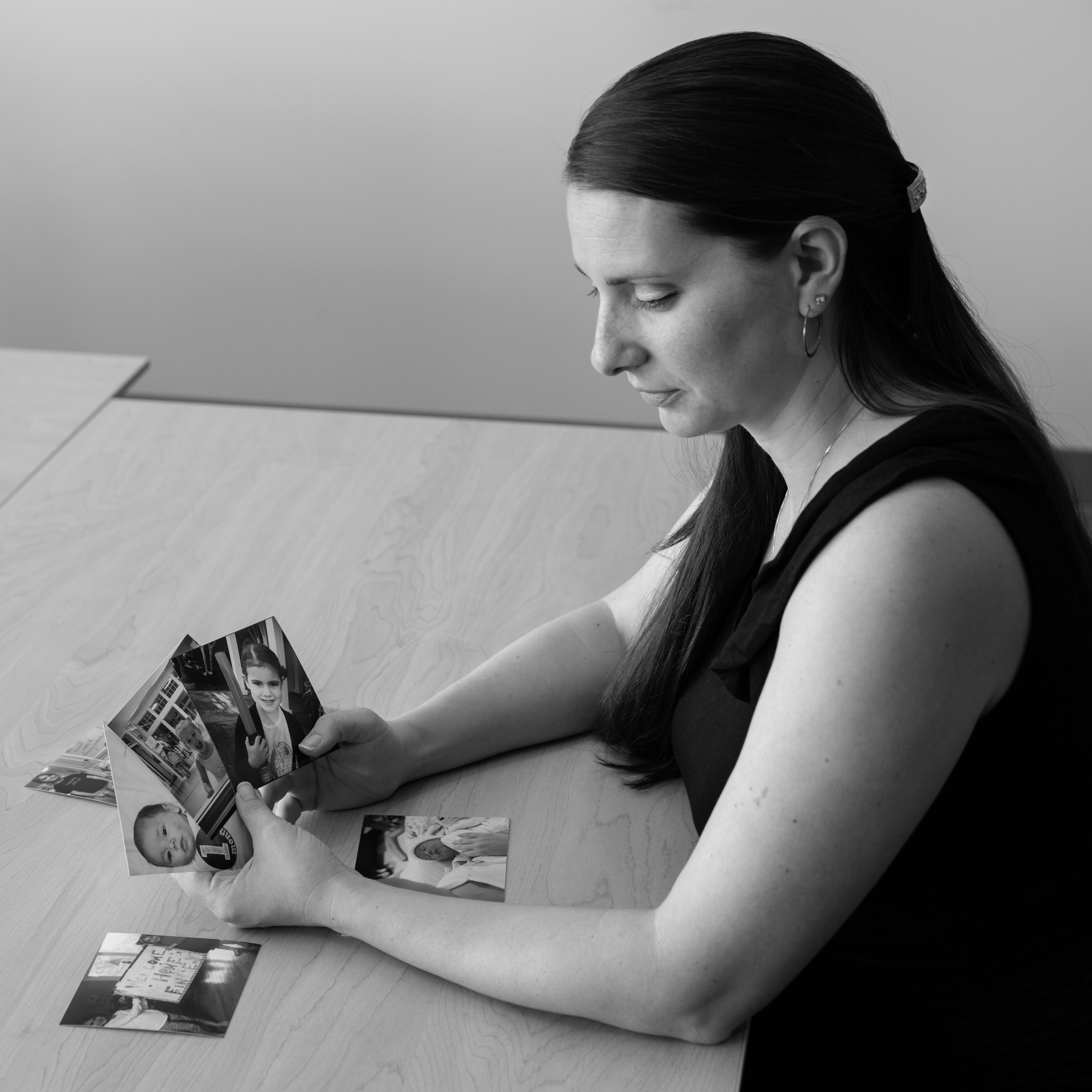 Woman sitting at table looking at photographs