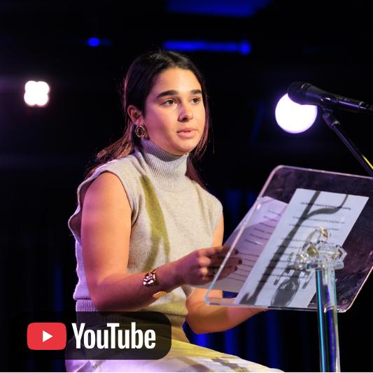 Video thumbnail featuring a person speaking at a podium onstage, with a YouTube icon.