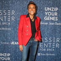 Woman in red jacket posing for a picture on the red carpet
